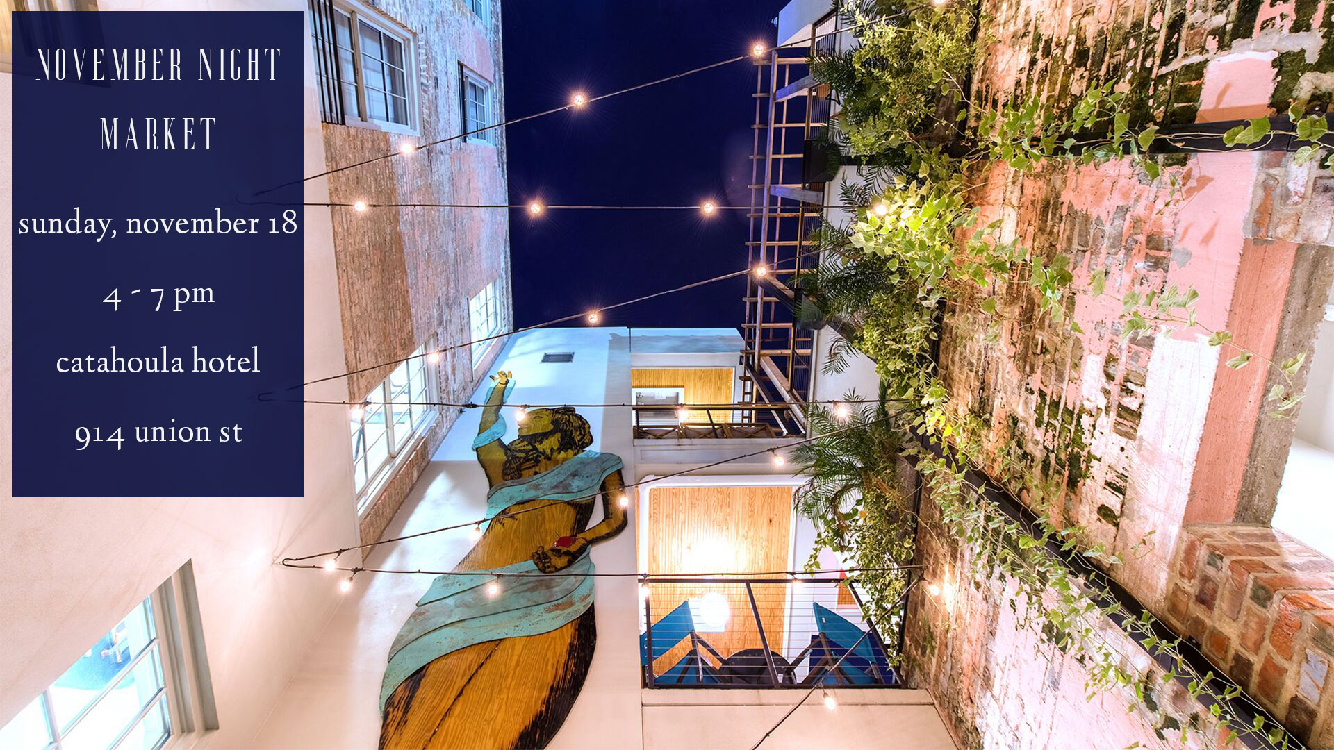 A nighttime view of a hotel courtyard with string lights, a green wall, and balconies.