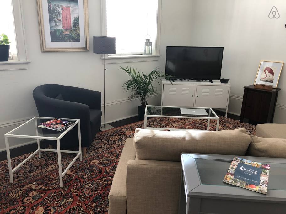 A cozy living room with a beige sofa, coffee table, and TV.