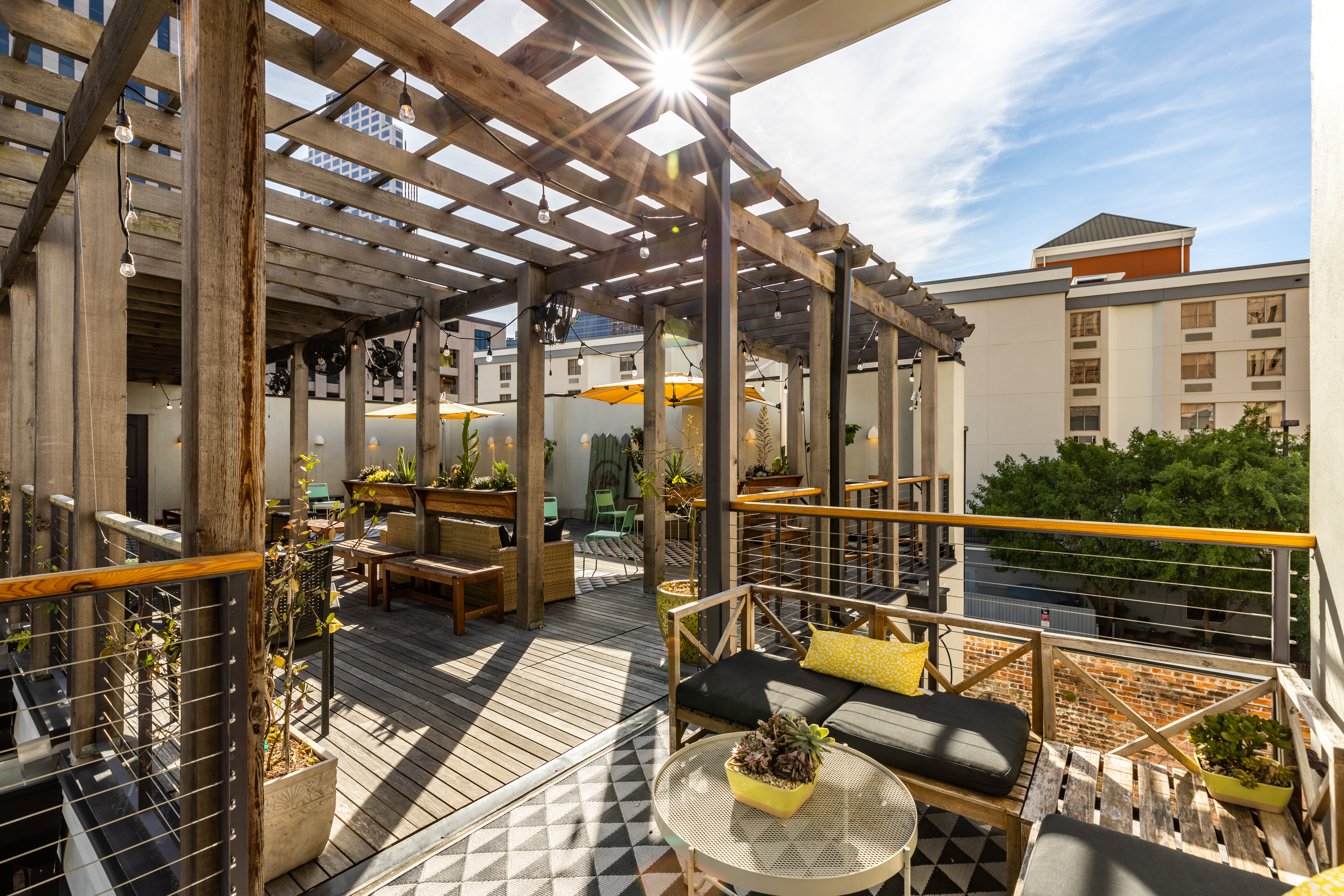 A pergola-covered outdoor seating area with furniture and plants.