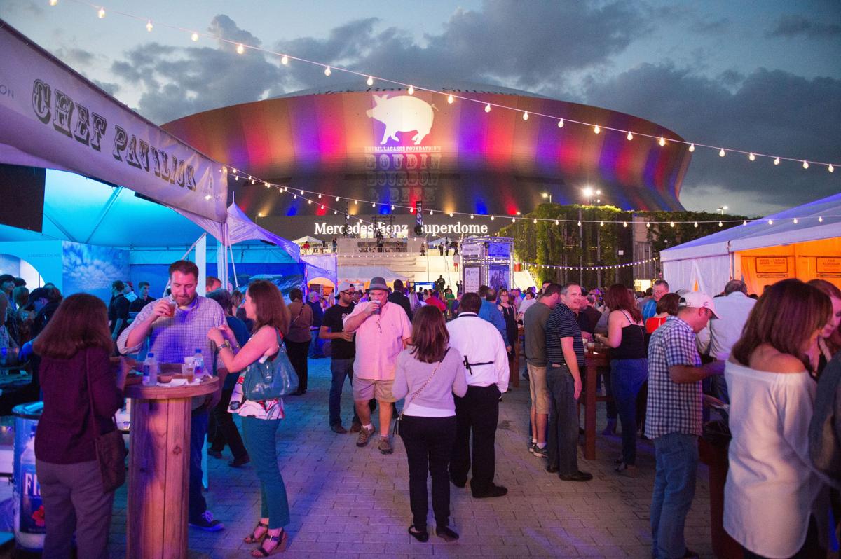 A large crowd of people at an outdoor event in front of the Mercedes-Benz Superdome.